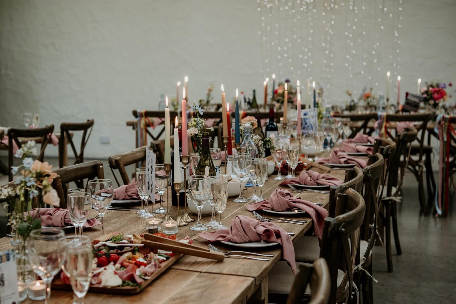 Rustic wooden table with charcuterie board and candle centrepieces