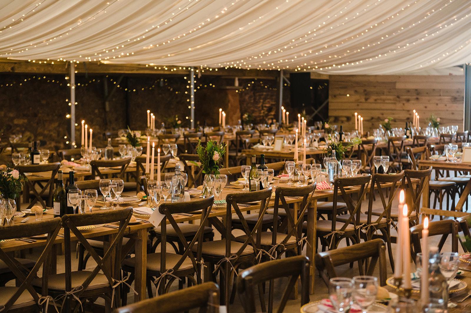 Wedding reception in a barn with stone walls and fairy lights