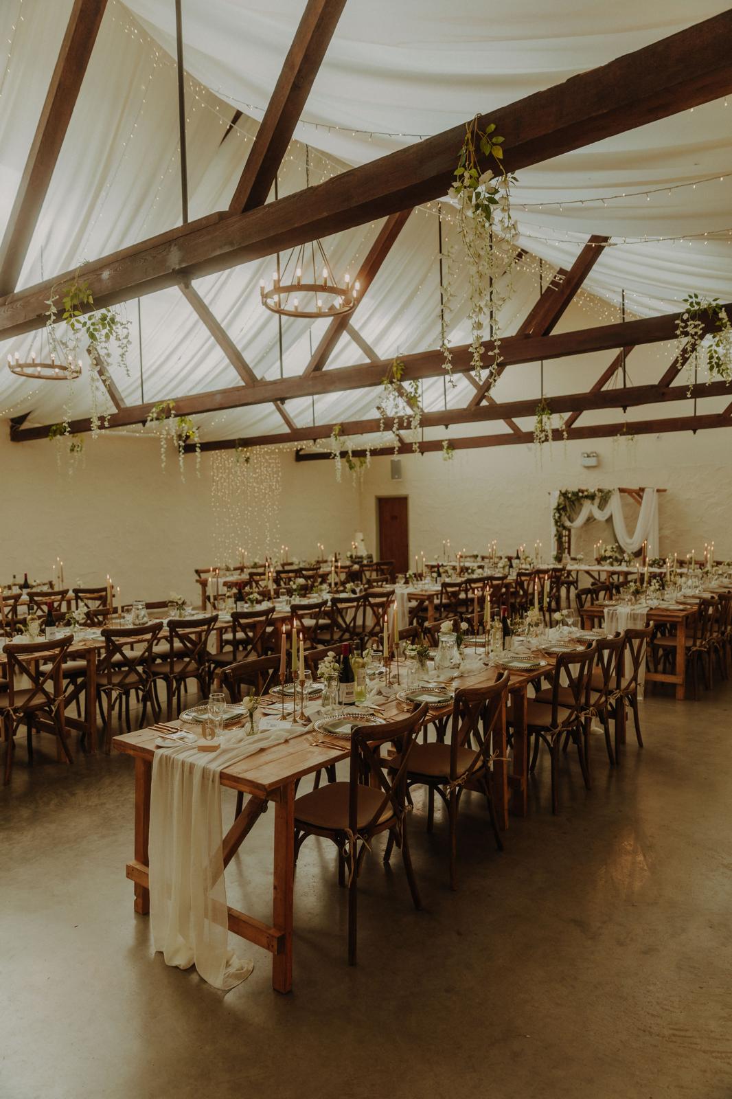Rustic banqueting setup with fairy lights and hanging greenery